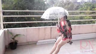 Summer rain in the garden. Naked nudist with a transparent umbrella on the terrace. Cute housewife has fun without panties on the swing Slut swings and shows her perfect pussy